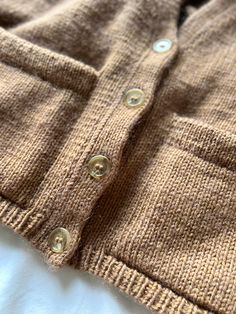 a close up of a sweater with buttons on it