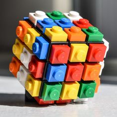 a multicolored cube made out of legos sitting on a table