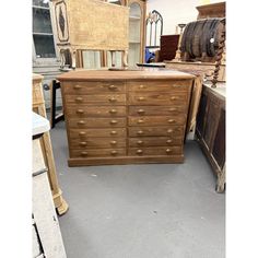 a wooden dresser sitting on top of a floor next to other pieces of furniture in a room