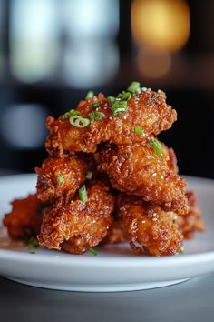 some fried food on a white plate with green onions and scallions in it