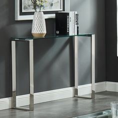 a glass table with some books on it and a vase full of flowers next to it