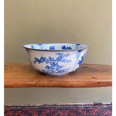 a blue and white bowl sitting on top of a wooden table