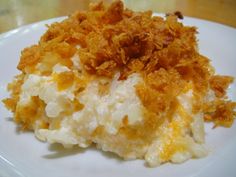 a white plate topped with mashed potatoes covered in cheese and crumbled on top