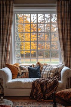 a white couch sitting in front of a window