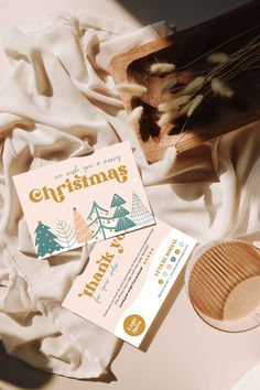 a close up of a wooden object on a bed with white sheets and paper next to it