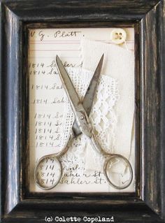 a pair of scissors sitting on top of a piece of paper next to a lace doily