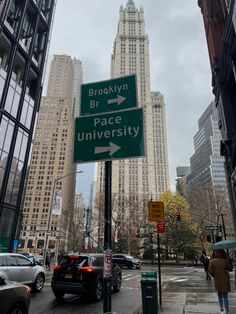 a street sign on the corner of brooklyn and peace university in front of tall buildings