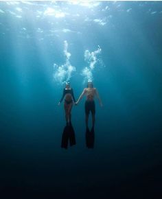 two people in the water holding hands