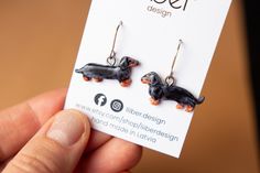 a pair of dachshund earrings is shown in front of a card