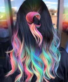 the back of a woman's head with multi - colored hair and black top