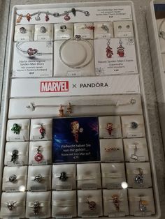 an assortment of jewelry on display in a box with the price tag for each item