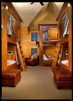 a room with bunk beds and couches inside of it, all made out of wood