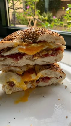 two sandwiches stacked on top of each other with cheese and meat in between the buns