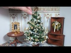 a miniature christmas tree in front of a small table with a mirror on it and other decorations