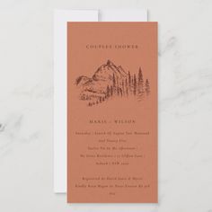 an orange and white wedding card with mountains in the background