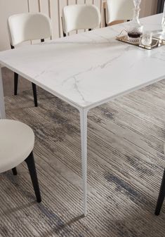 a white marble dining table with chairs around it