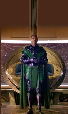 a man dressed in green and purple standing next to a giant object with his hands on his hips