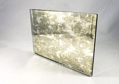 a silver and white marbled mirror on a white background