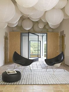 a room with some chairs and paper lanterns hanging from it's ceiling over the doorway