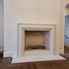 an empty room with a fireplace in the middle