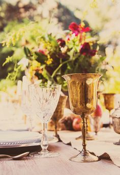 a table topped with glasses and plates covered in flowers