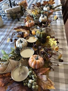 a long table covered in lots of pumpkins and leaves