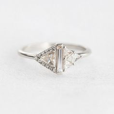 a three stone diamond ring on a white background