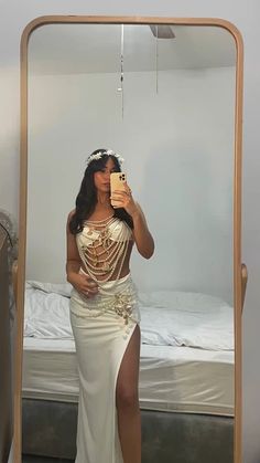 a woman taking a selfie in front of a mirror wearing a white dress and holding a cell phone