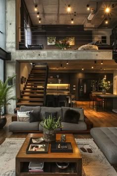 a living room filled with lots of furniture and a staircase leading up to the top floor