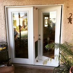 an open door to a patio with potted plants