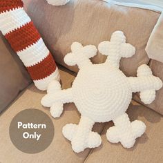 a crocheted turtle sitting on top of a couch next to a red and white pillow