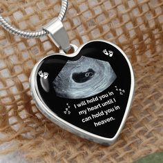 a heart shaped pendant with an image of a cat on it's side and the words will hold you in my heart until i can hold you in heaven