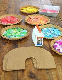 paper plates are sitting on a wooden table with paint and crafting supplies around them