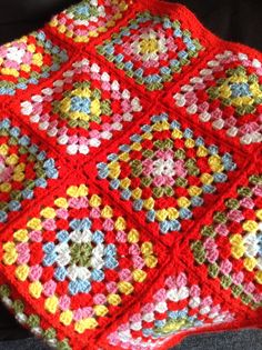 a crocheted blanket is sitting on a couch