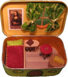 an open suitcase filled with miniature furniture and pictures on the wall next to a postage stamp