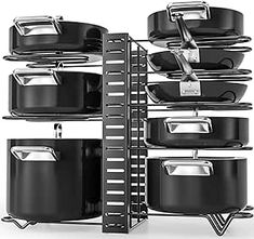 black pots and pans are stacked up on a rack with a ladder to reach them