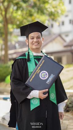 a man wearing a graduation gown and holding a book