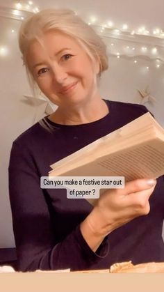 a woman is reading a book with a caption that reads can you make a festive star out of paper?