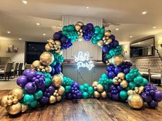 an arch made out of balloons with the words let's party written on it