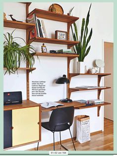 a desk with two chairs and a shelf filled with books, plants and other items