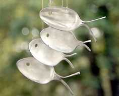 four spoons are hanging from a string in the shape of birds on a branch