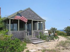 a house with an american flag on the roof and a bike parked in front of it