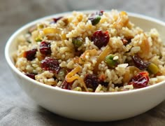 a white bowl filled with rice and cranberries