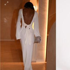 the back of a woman's white dress is seen in this image and on the right