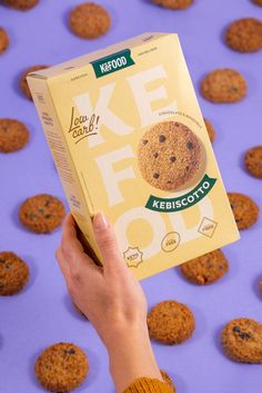 a person holding up a box of krispy kreme cookies