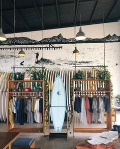 a surfboard is on display in a shop with other surfboards hanging from the ceiling