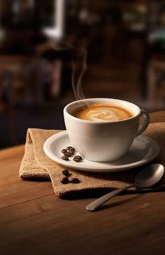 a cup of coffee sitting on top of a wooden table