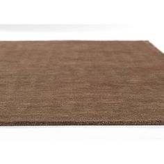 a brown area rug on top of a white floor with no one in the room