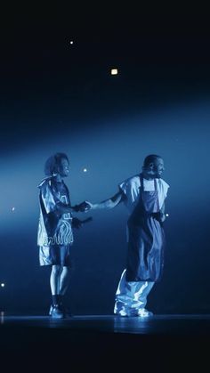 two people on stage shaking hands with each other