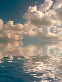 the sky is filled with clouds and reflecting on the water's surface as if it were floating in the ocean